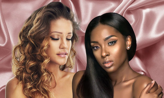Black woman with straight hair, white woman with curly hair in front of pink satin fabric backdrop