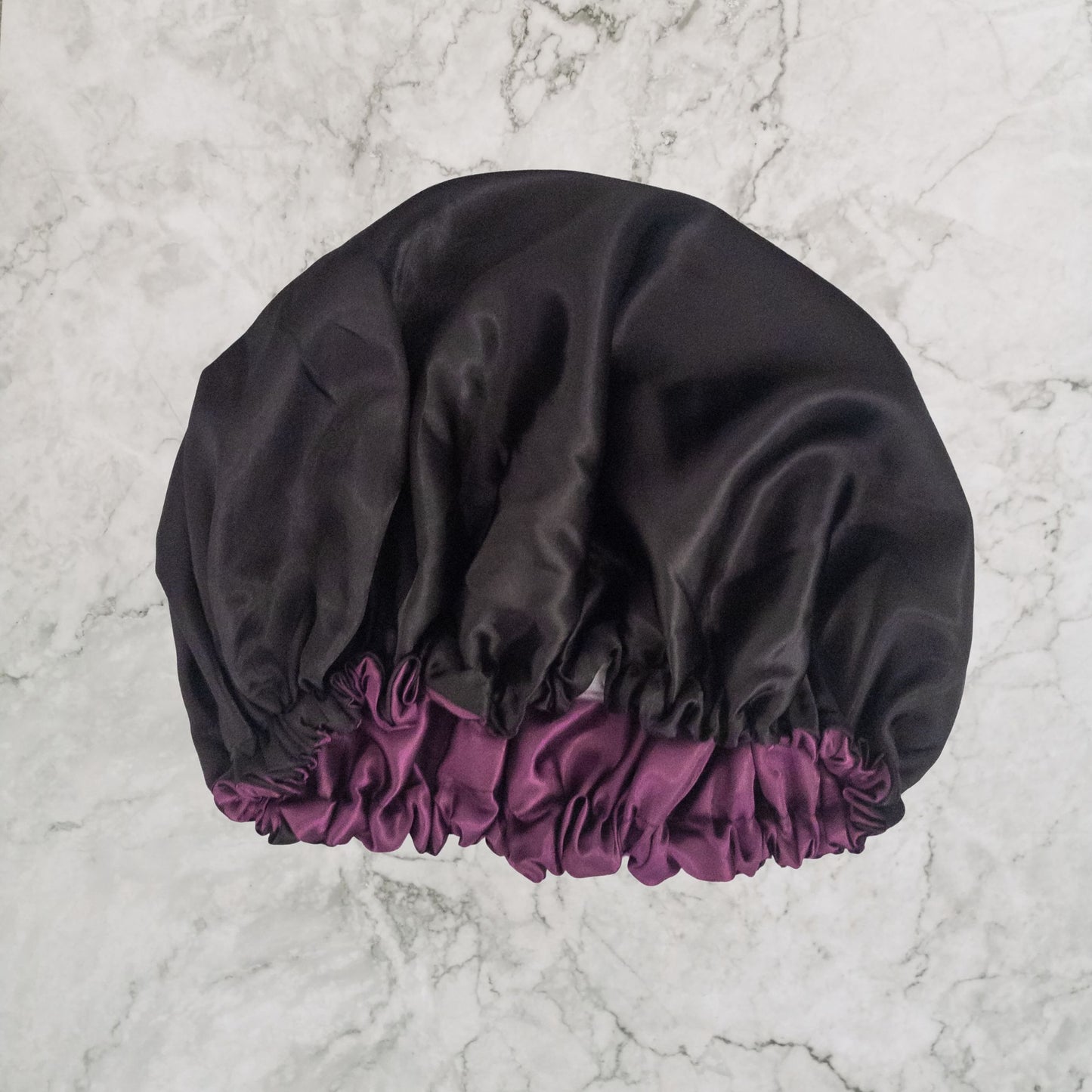 Hair Wrap Heaven STAY ON satin bonnet with adjustable elastic - Purple and black in reverse showing black lining