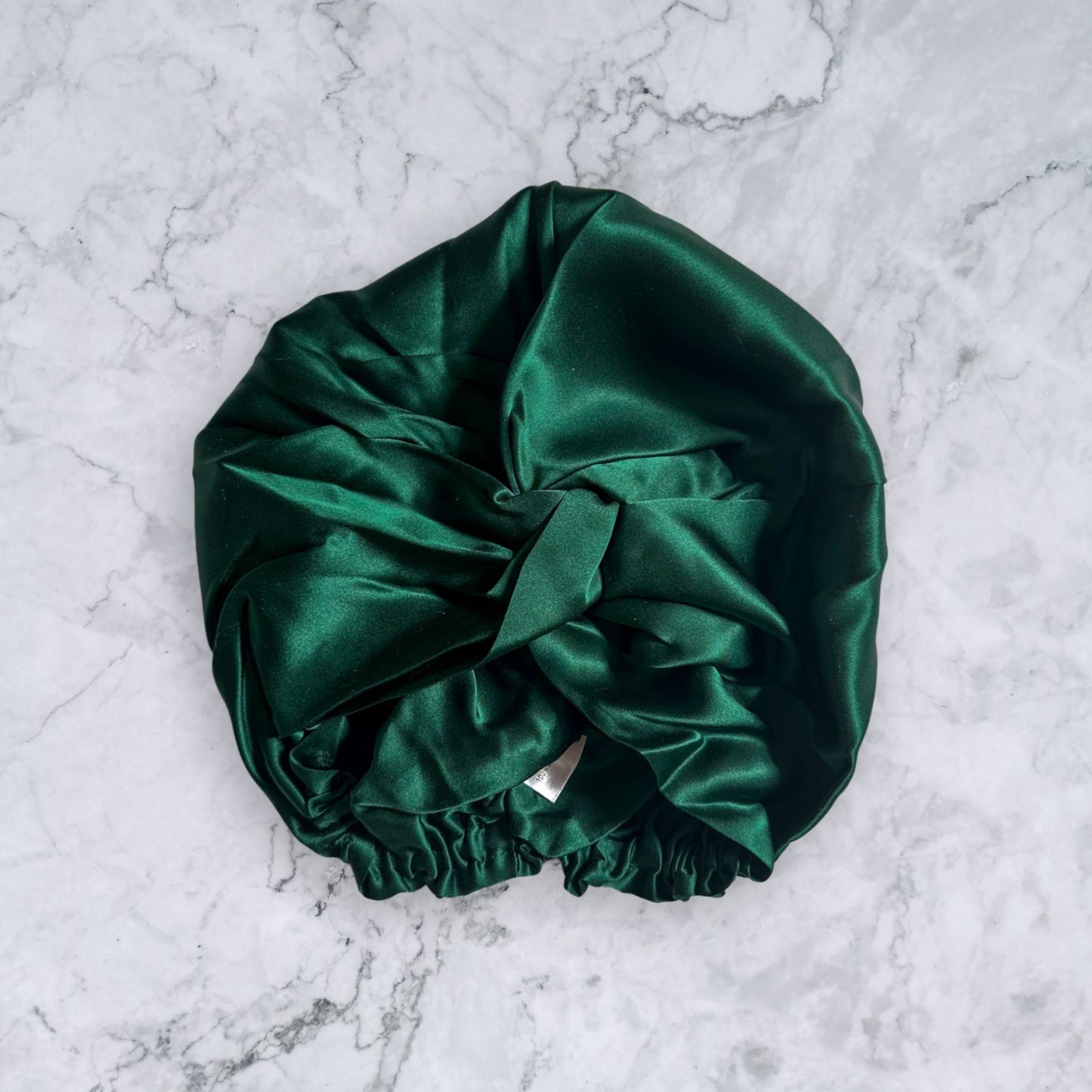 silk bonnet with twist detail to front elastic to back - dark green front view
