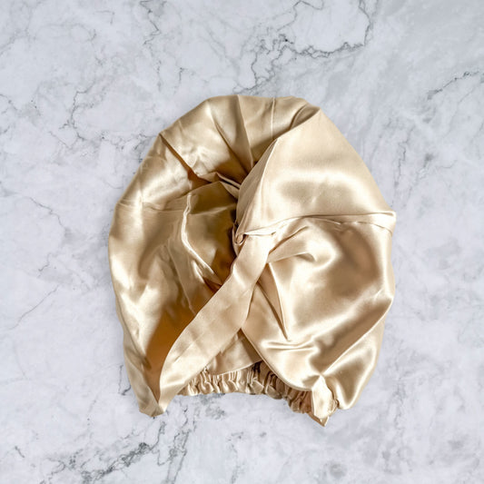 silk bonnet with twist detail to front elastic to back - champagne nude front view