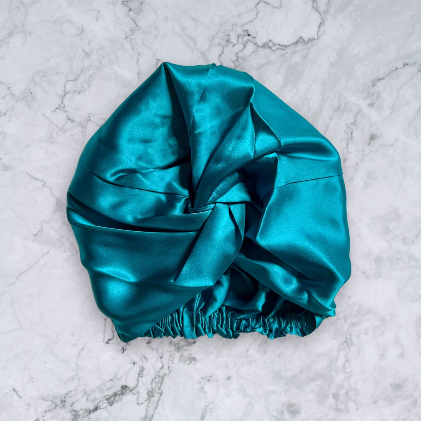 silk bonnet with twist detail to front elastic to back - teal front view
