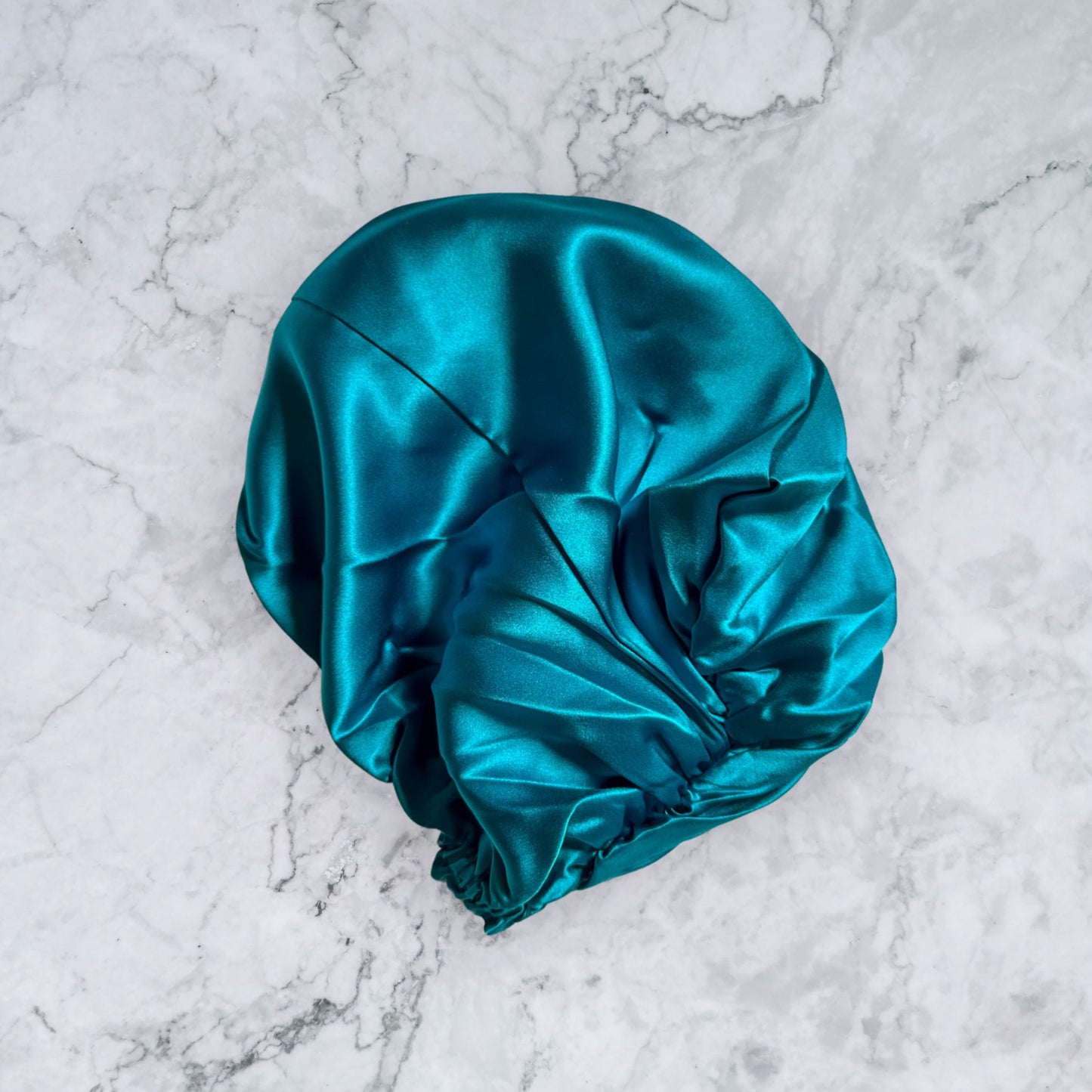 silk bonnet with twist detail to front elastic to back - teal rear view