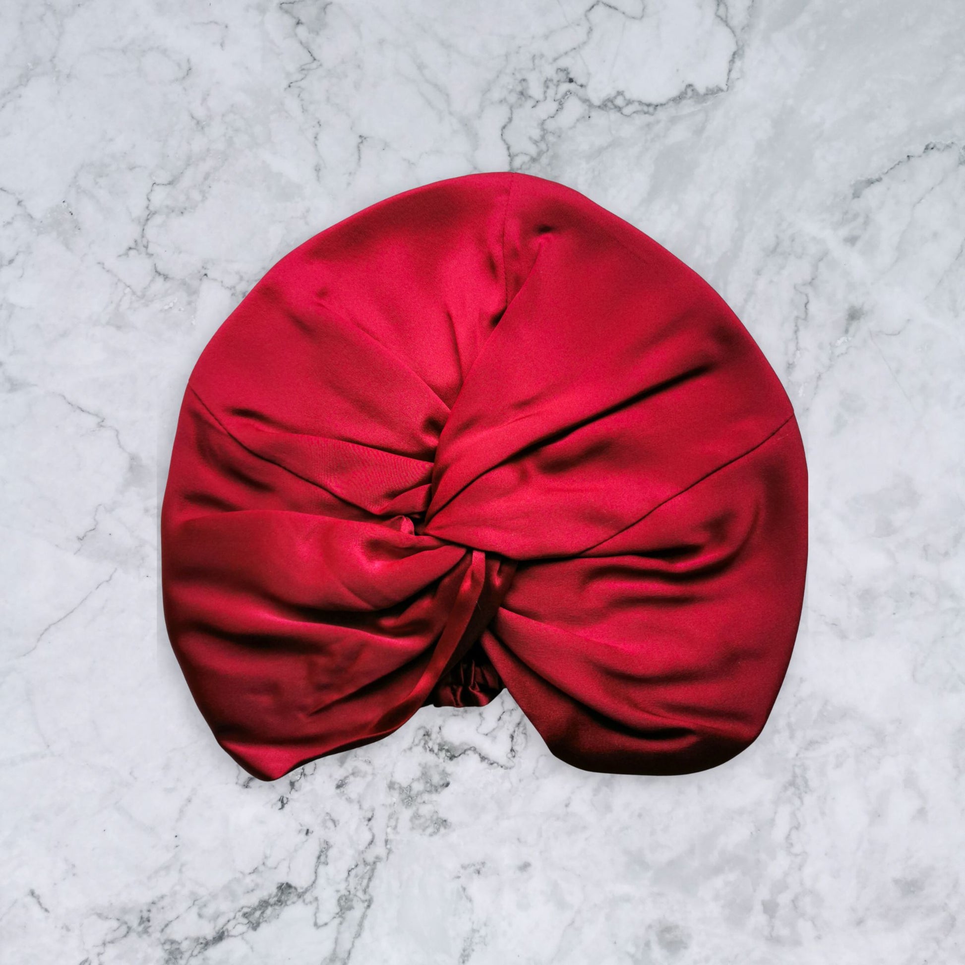 Red silk turban on a marble surface