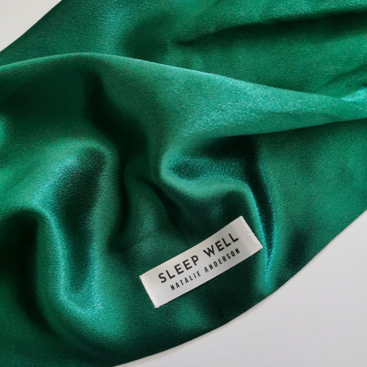 satin hair wrap with sleep well label in bottle green